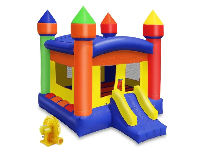 Cloud 9 commercial castle bounce house with orange, green, red and yellow turrets, a blue base and a small double slide, its blower beside it