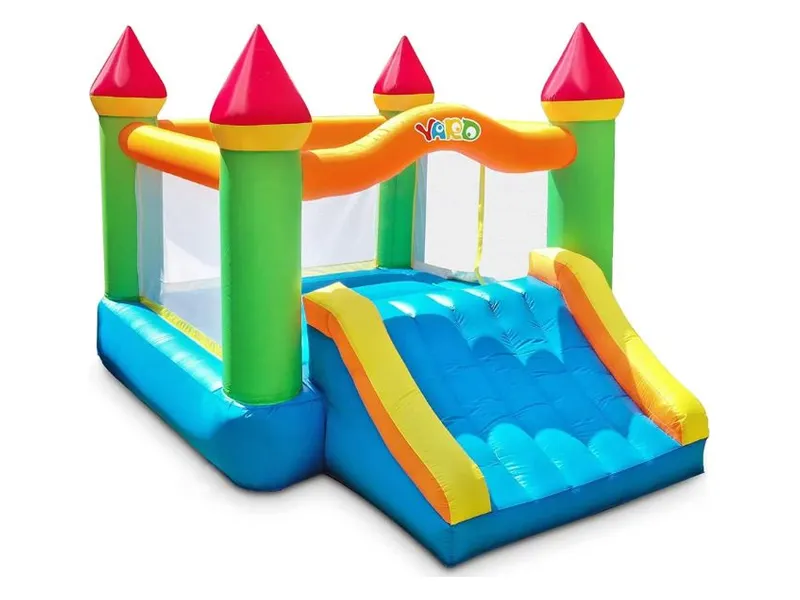 YARD castle bounce house with red turrets and a blue slide